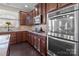 Kitchen with stainless steel oven, gas cooktop, dark wood cabinets, and granite countertops at 3181 Helmsley Ct, Concord, NC 28027