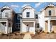 New construction townhome exterior showing siding and windows in a bright midday sun with small foliage around the walkway at 336 A Lincoln St, Concord, NC 28025