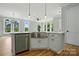 Kitchen island featuring a stainless steel farmhouse sink, white cabinets, and hardwood floors at 409 Henry Chapel Rd, Belmont, NC 28012