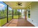 Screened-in porch with wood flooring and a ceiling fan, offering a relaxing outdoor space with views of the lush surroundings at 409 Henry Chapel Rd, Belmont, NC 28012