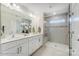 A bathroom features double sinks, quartz countertops, updated fixtures, and a tiled walk-in shower at 4211 Black Ct # 193, Harrisburg, NC 28075