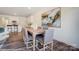 A dining area features wood floors, a table with seating, modern art, and an adjacent modern kitchen at 4211 Black Ct # 193, Harrisburg, NC 28075