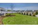 Expansive backyard featuring lush green grass, tasteful landscaping, and a charming paver patio at 4219 Huntley Glen Dr, Pineville, NC 28134