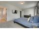 A bright primary bedroom with light gray walls, a TV, and ensuite bathroom exudes simple sophistication at 4219 Huntley Glen Dr, Pineville, NC 28134