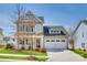 Charming two-story home with a well-manicured lawn, a covered front porch, and an attached two-car garage at 4219 Huntley Glen Dr, Pineville, NC 28134