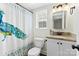 Bright bathroom with granite counters, cabinet storage, and peacock-themed shower curtain at 4921 Park Rd # C, Charlotte, NC 28209