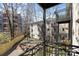 Balcony view of courtyard featuring outdoor seating, mature trees, and white brick buildings at 4921 Park Rd # C, Charlotte, NC 28209