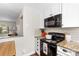Well-lit kitchen features granite counters, white cabinetry, and a view of the living area at 4921 Park Rd # C, Charlotte, NC 28209