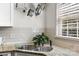 Close-up of kitchen sink featuring granite countertops and subway tile backsplash at 4921 Park Rd # C, Charlotte, NC 28209