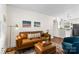 Bright living room features a stylish leather sofa, ottoman, and modern decor at 4921 Park Rd # C, Charlotte, NC 28209
