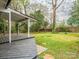 Large, green backyard featuring mature trees and a back porch at 5426 Milford Rd, Charlotte, NC 28210