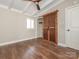 Bedroom features hardwood floors, ceiling fan, and rustic wood sliding barn door at 5426 Milford Rd, Charlotte, NC 28210