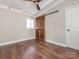 Bedroom features hardwood floors, ceiling fan, and rustic sliding barn door at 5426 Milford Rd, Charlotte, NC 28210