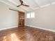 Bedroom with wood floors, ceiling fan and modern, sliding barn door to the closet at 5426 Milford Rd, Charlotte, NC 28210