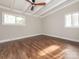 Bedroom features wood-look flooring, a ceiling fan, and bright, natural light from two windows at 5426 Milford Rd, Charlotte, NC 28210