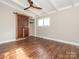 Bedroom with wood floors, ceiling fan and modern, sliding barn door to the closet at 5426 Milford Rd, Charlotte, NC 28210