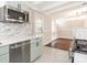 Open kitchen and living room view showcases marble countertops, stainless appliances, and bright, airy space at 5426 Milford Rd, Charlotte, NC 28210