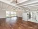 Open-concept living room with exposed beam ceiling, hardwood floors, and bright natural light at 5426 Milford Rd, Charlotte, NC 28210