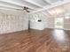 Open-concept living room featuring hardwood flooring, an exposed beam ceiling, and an attached kitchen at 5426 Milford Rd, Charlotte, NC 28210