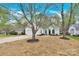 Landscaped front yard with trees framing a single story home with white siding at 5923 Carriage Oaks Dr, Charlotte, NC 28262