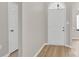 A bright hallway with wood grain floors leads to a white door at 5923 Carriage Oaks Dr, Charlotte, NC 28262