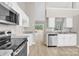 Bright kitchen with stainless steel appliances, white cabinetry and modern countertops at 5923 Carriage Oaks Dr, Charlotte, NC 28262