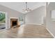 Open-concept living room featuring a brick fireplace, ceiling fan, and plenty of natural light at 5923 Carriage Oaks Dr, Charlotte, NC 28262
