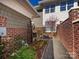 Private patio featuring pavers, a walkway, decorative flowers, small garden, and brick privacy wall at 6301 Park South Dr, Charlotte, NC 28210
