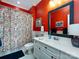 Vibrant bathroom with bright red walls, double vanity, and colorful shower curtain at 6301 Park South Dr, Charlotte, NC 28210