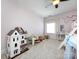 Spacious bedroom with light pink walls, dollhouse, and large window at 6301 Park South Dr, Charlotte, NC 28210