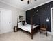 Dark wood sleigh bed and accent wall covered in white stars in spacious bedroom at 6301 Park South Dr, Charlotte, NC 28210