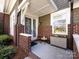 Inviting front porch with brick columns, a seating area, and seasonal decor at 6301 Park South Dr, Charlotte, NC 28210