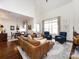 Open-concept living room with hardwood floors, large windows, and seamless flow to the dining area at 6301 Park South Dr, Charlotte, NC 28210