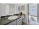 Bright bathroom featuring a sink with gray cabinets, a mirror, and a shower with sliding glass doors at 6310 Windsor Gate Ln # 15, Charlotte, NC 28215
