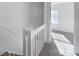 Bright hallway features carpeted floors, white railings, and a window at the end of the hall at 6310 Windsor Gate Ln # 15, Charlotte, NC 28215