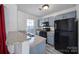 Bright kitchen features gray cabinets, black appliances, granite countertops, and a stainless steel sink at 6310 Windsor Gate Ln # 15, Charlotte, NC 28215