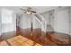 Open-concept living room with hardwood floors, ceiling fan, and staircase to upper level at 6310 Windsor Gate Ln # 15, Charlotte, NC 28215