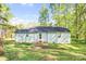 A view of the flat backyard with a small patio surrounded by mature trees creating a private outdoor space at 6628 Cool Water Ct, Charlotte, NC 28215