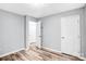 Neutral bedroom with wood-look flooring, white door, trim, and a door that is ajar at 6628 Cool Water Ct, Charlotte, NC 28215