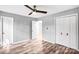 Neutral bedroom with wood-look flooring, ceiling fan, closet, and white trim at 6628 Cool Water Ct, Charlotte, NC 28215