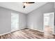 Bright bedroom featuring wood-look floors, ceiling fan, and access to the backyard with a glass paneled door at 6628 Cool Water Ct, Charlotte, NC 28215