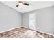 Light-filled bedroom with a ceiling fan, hardwood floors, a closet, and a door to the exterior at 6628 Cool Water Ct, Charlotte, NC 28215