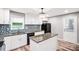 Renovated kitchen with white cabinets, granite countertops, a center island, and stainless steel appliances at 6628 Cool Water Ct, Charlotte, NC 28215