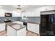 Modern kitchen featuring white cabinets, granite countertops, a center island, and stainless steel appliances at 6628 Cool Water Ct, Charlotte, NC 28215