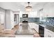 Bright kitchen with white cabinetry, granite counters, mosaic backsplash, and a center island at 6628 Cool Water Ct, Charlotte, NC 28215