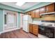 View of a compact kitchen with wood cabinets and white appliances at 7213 Quail Meadow Ln, Charlotte, NC 28210