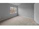 Clean and simple bedroom with neutral carpet and ample natural light from the window at 7707 Petrea Ln, Charlotte, NC 28227