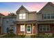 Inviting two-story townhouse features brick accents and a charming front porch at sunset at 7707 Petrea Ln, Charlotte, NC 28227