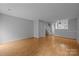 Open living space with hardwood floors, stairs, and view into the kitchen at 7707 Petrea Ln, Charlotte, NC 28227