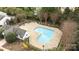 Aerial view of fenced community pool area with trees, chairs and pool house at 7707 Petrea Ln, Charlotte, NC 28227
